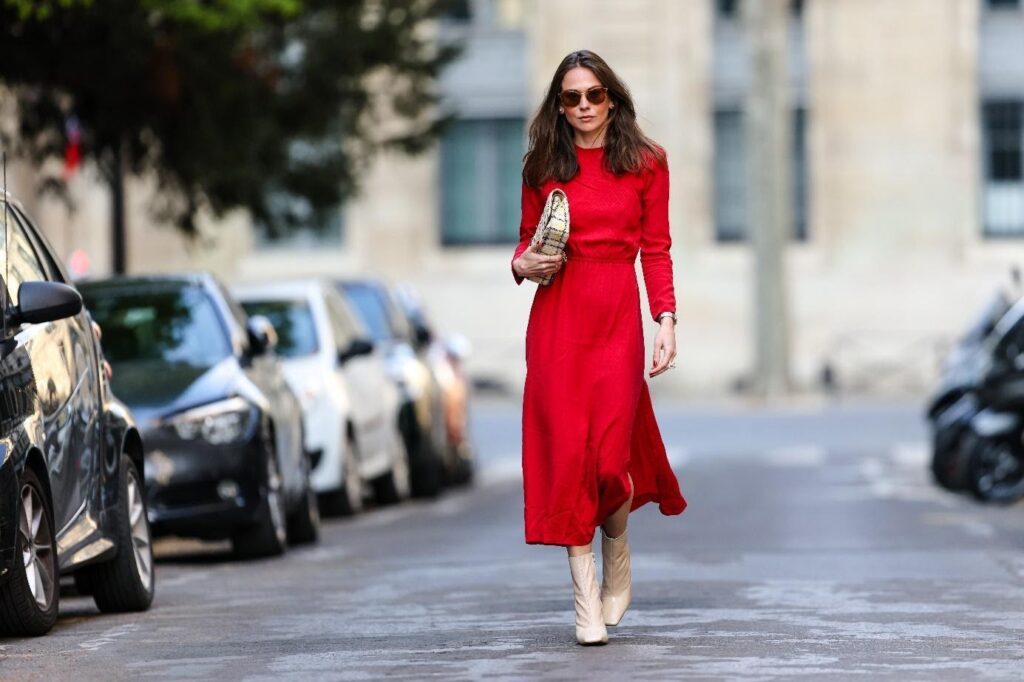 Egy nő piros ruhában és bézs bokacsizmában