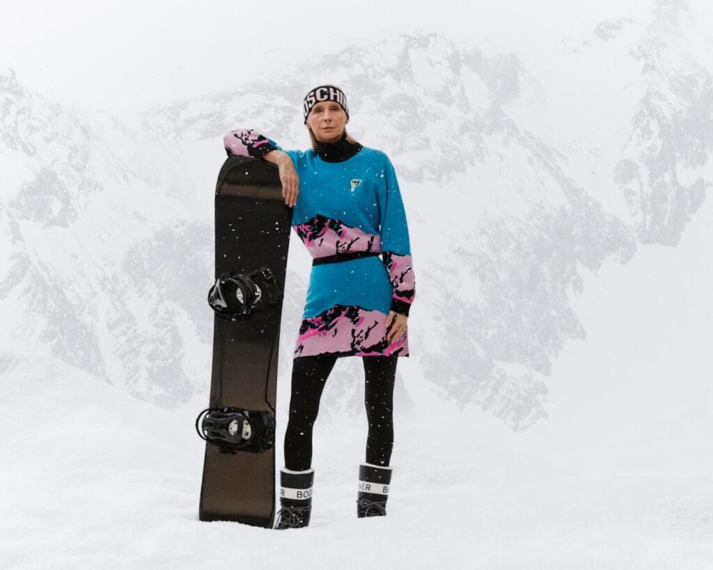 Színesen öltözött nő snowboard deszkával