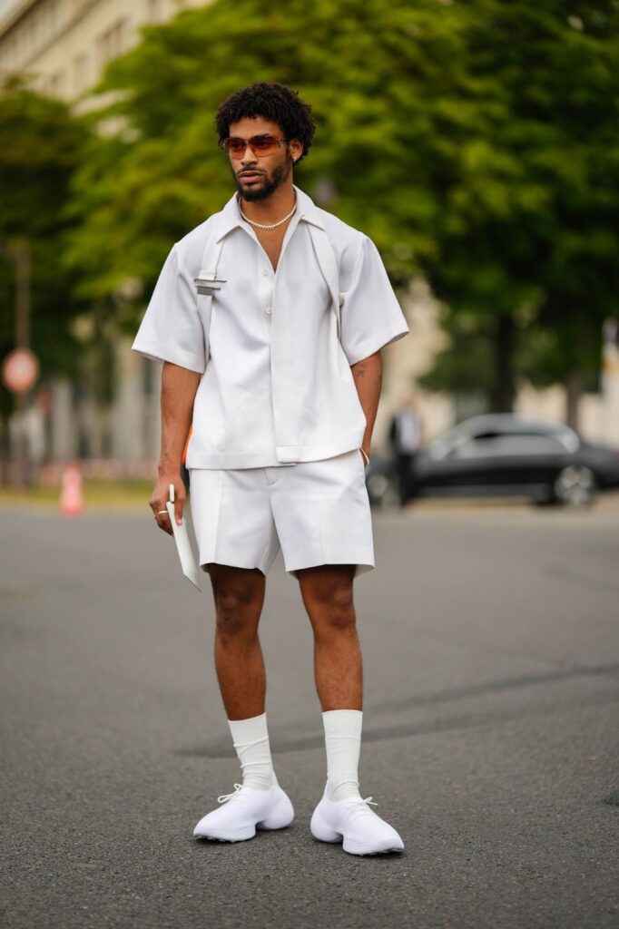 Férfi vászon ingben és rövidnadrágban és fehér sneakerben