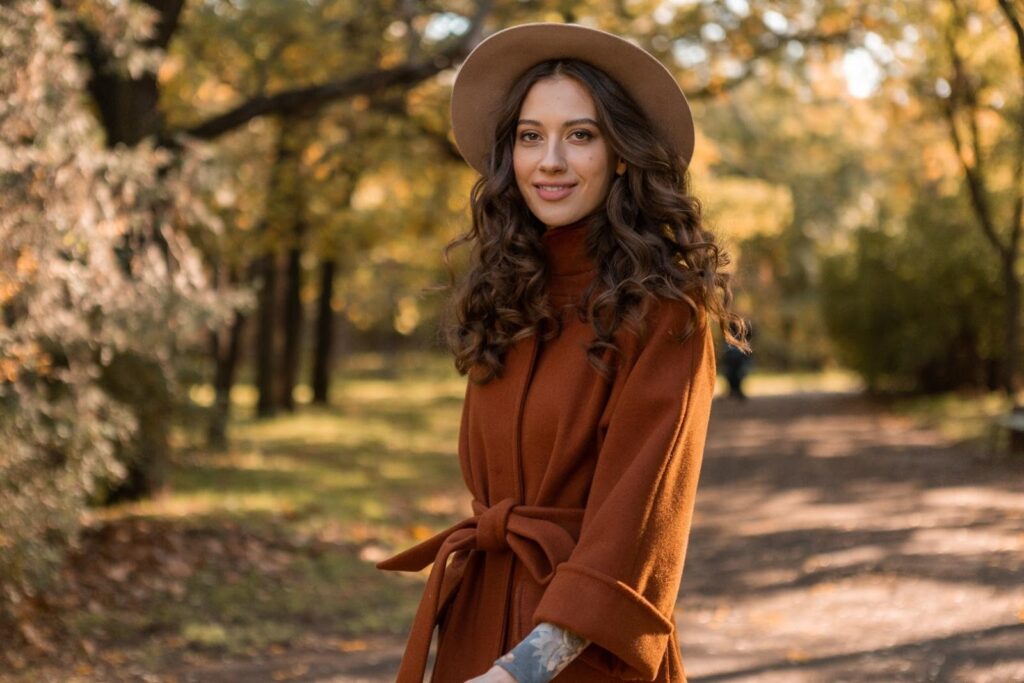 Lány a parkban barna kabátban és világosbarna kalapban