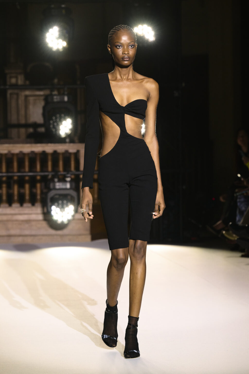 Egy kivágott ruhás modell végigsétál a Monot kifutóján a 2022-es Párizsi Divathéten