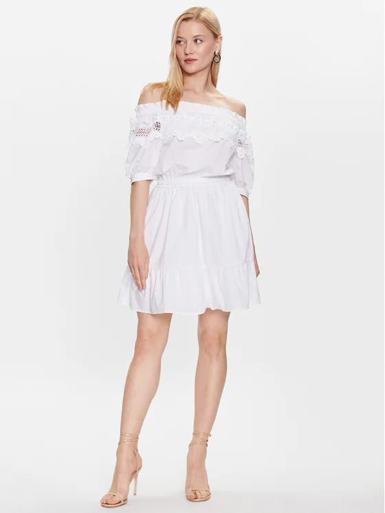 Egy boho stílusú, fehér nyári ruhát viselő nő