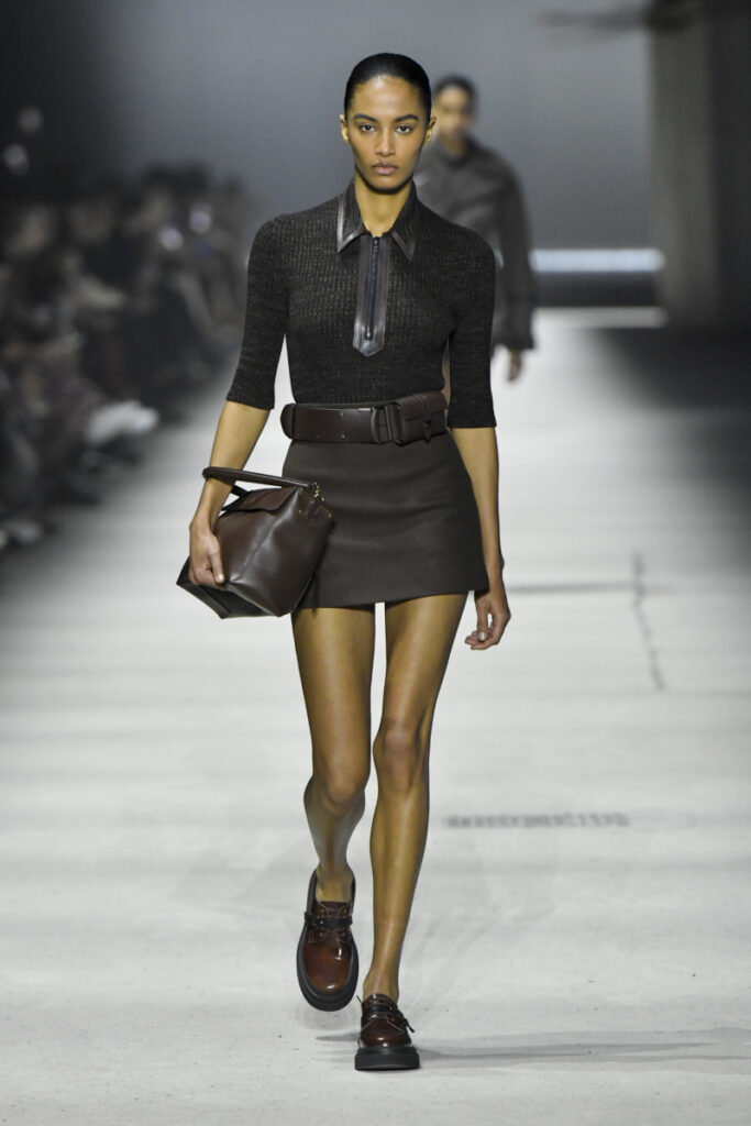 Tod's márkájú, barna mokaszint viselő modell a kifutón