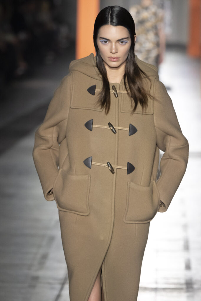 egy vastag, bézs színű, Paddington stílusú kabátot viselő modell