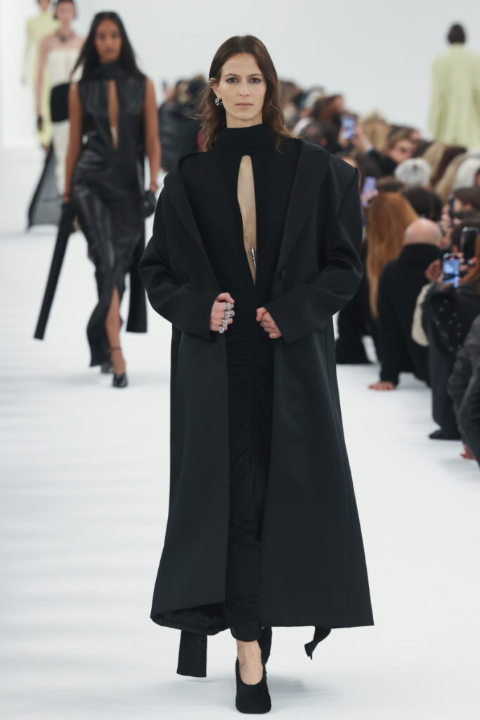 Egy divatos kabátot viselő modell a Givenchy bemutatóján