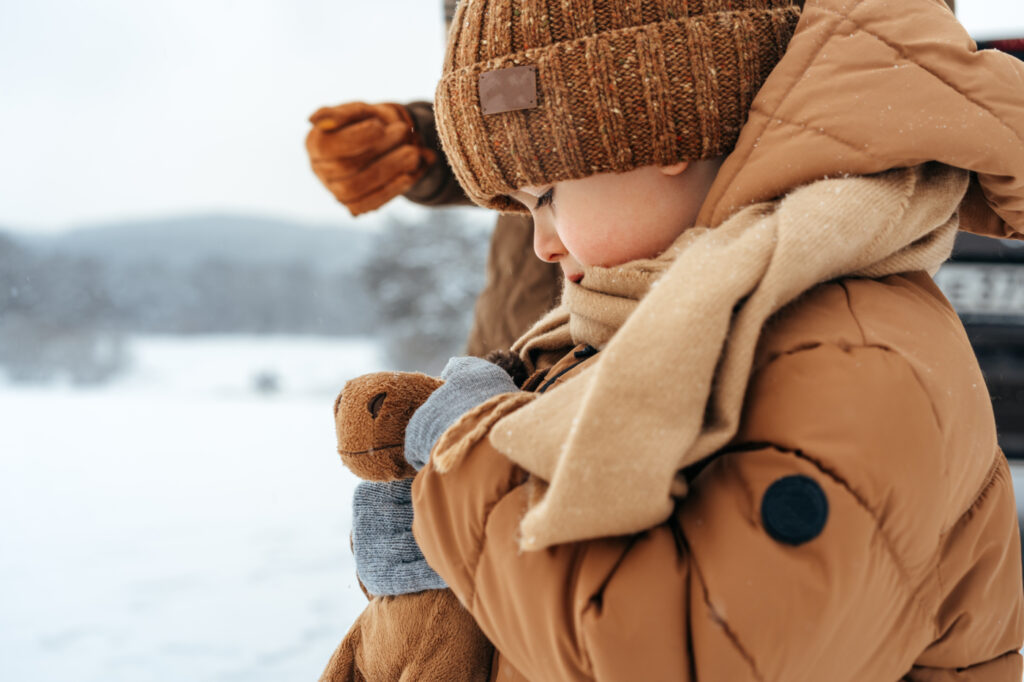 Kisfiú egy bézs színű gyerek téli dzsekiben 