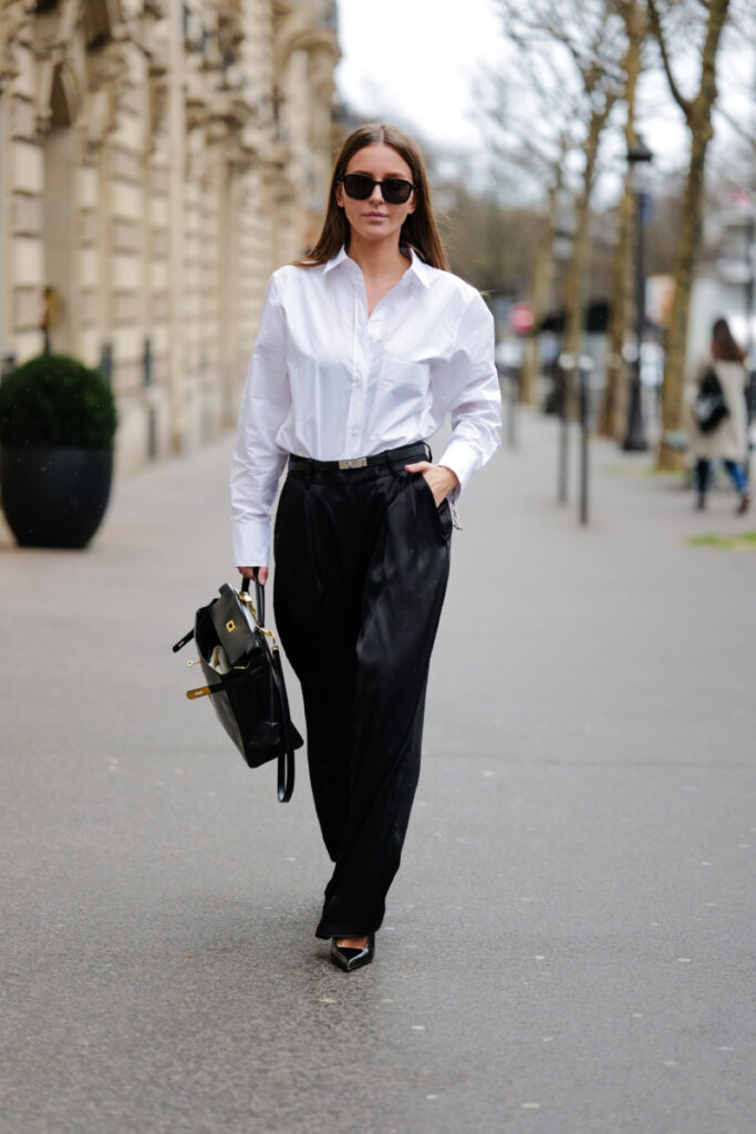 Diane Batoukina fehér ingben, Hermés táskával és fekete kosztümnadrágban