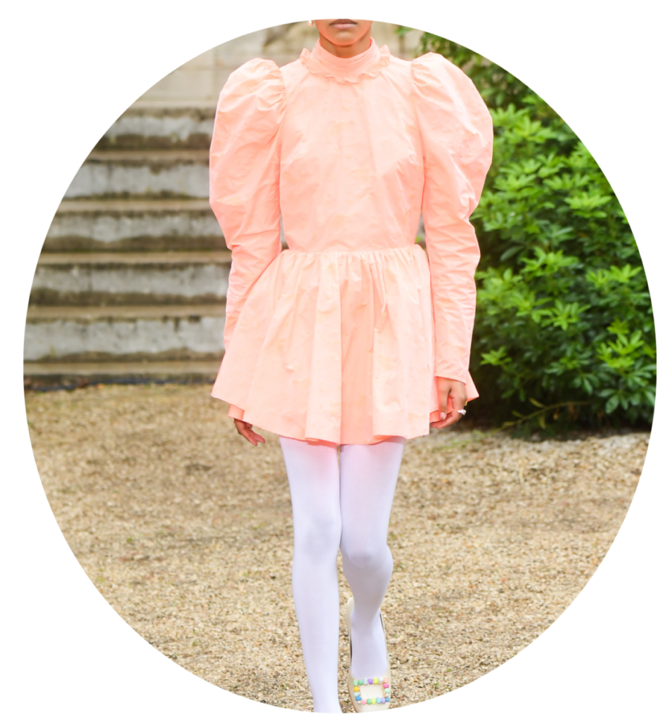 A Pantone 2024-es év színe: peach fuzz ruha, fehér harisnya és cipő, színes csattal díszítve