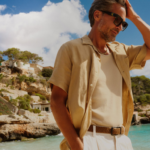 férfi a tengerparton, világos nadrágban és rövid ujjú lenvászon ingben
